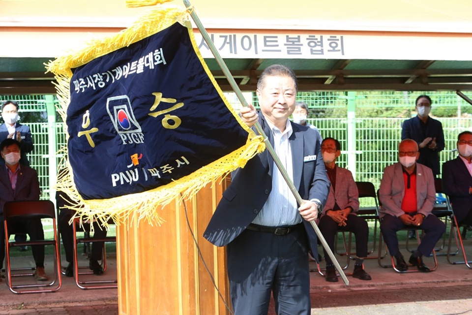 김경일시장이 전년도 우승팀으로부터 우승기를 전달받아 좌우로 흔들어 보이고 있다.