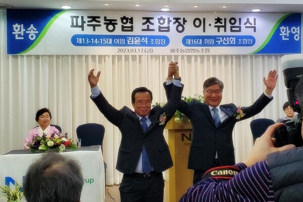 구선회 조합장이 전 김윤석조합장과 두팔을 높이 추켜들며 이취임식 퍼포먼스를 펼쳤다.