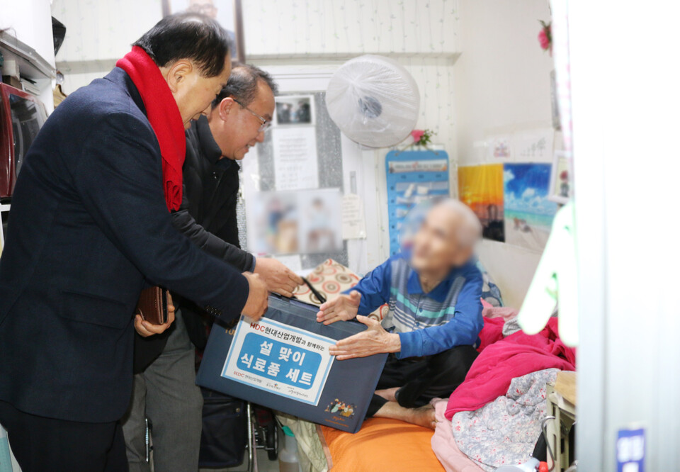 HDC현대산업개발이 쪽방촌 거주 주민에게 설 맞이 식료품 세트를 전달하고, 김용호 시의원(왼쪽 첫 번째)과 함께 설 명절 인사를 나누고 있다.